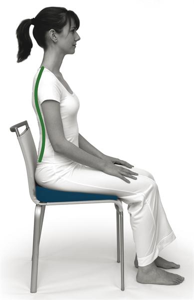 A side on image of a lady wearing white trousers and a top. She is sat upright with her hands on her legs on a chair. There is a red line that is overlaid on her spine showing the optimum curves of the spine