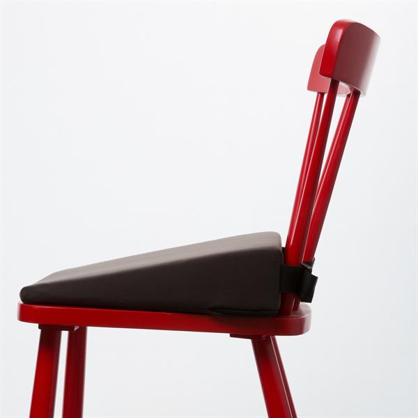 A side on view of a Harley 11 degree wedge with a fixing strap to hold it in place. The 11 degree wedge is placed on top of a simple red wooden chair and you can see how the strap can be tightened such that you can tell it will never move off the chair as you move to stand up and sit down.