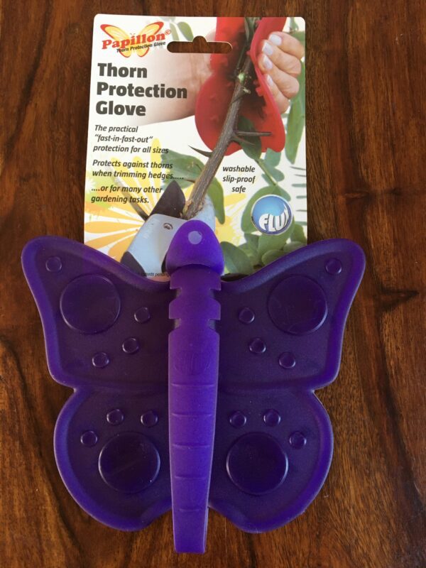 A photo of a purple Papillon Thorn Protection glove. It is made from malleable plastic and shaped like a butterfly. It has a label above giving the name of the product and a photographic example of someone using it. It is folded around a rose stem with the thorns and is protecting the users hand.