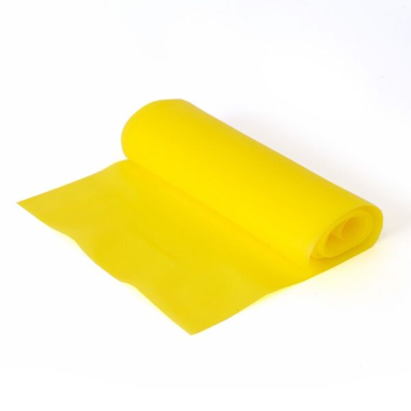 On a white background is a Yellow Fun and Active resistance band. It is lying on its side rolled up with just the last few centemeters rolled out flat on the floor.