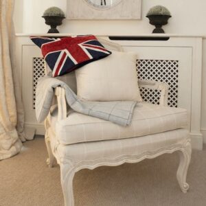 Sittingwell Cushion on a deep cream chair. Drapped over the back of the chair is a union jack cushion cover and leaning against the back of the chair is a Sittingwell back support for the sofa and deep chairs similar to the one it is displayed on. The Sittingwell cushion does just look like a white square - the inside of a cushion before the cover goes on, that's the magic of it, no one ever knows and your home looks as fab as ever