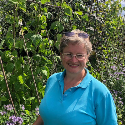 Rachael Kennard-Wall Its All About Health Rachael Kennard-Wall standing next to bean canes in her allotment at its all about health garden